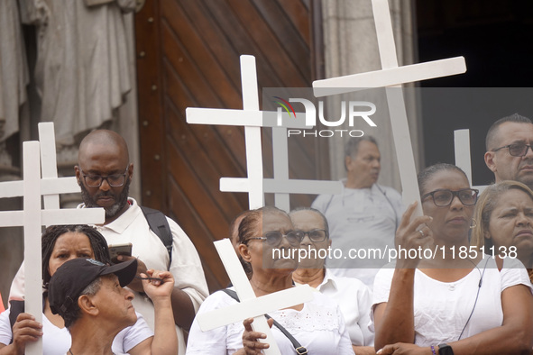 People hold crosses during a demonstration in downtown Sao Paulo, Brazil, on December 9, 2024, to protest against police violence following...