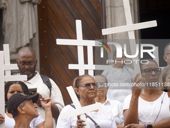 People hold crosses during a demonstration in downtown Sao Paulo, Brazil, on December 9, 2024, to protest against police violence following...