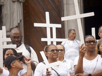 People hold crosses during a demonstration in downtown Sao Paulo, Brazil, on December 9, 2024, to protest against police violence following...