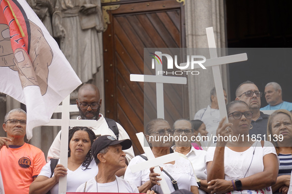 People hold crosses during a demonstration in downtown Sao Paulo, Brazil, on December 9, 2024, to protest against police violence following...