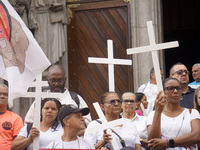 People hold crosses during a demonstration in downtown Sao Paulo, Brazil, on December 9, 2024, to protest against police violence following...