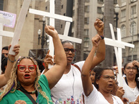 People hold crosses during a demonstration in downtown Sao Paulo, Brazil, on December 9, 2024, to protest against police violence following...