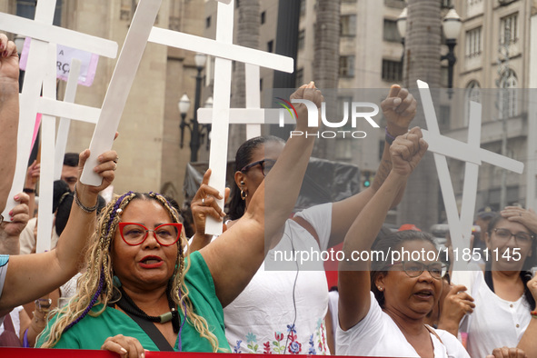 People hold crosses during a demonstration in downtown Sao Paulo, Brazil, on December 9, 2024, to protest against police violence following...