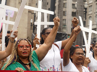 People hold crosses during a demonstration in downtown Sao Paulo, Brazil, on December 9, 2024, to protest against police violence following...