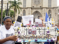 People hold crosses during a demonstration in downtown Sao Paulo, Brazil, on December 9, 2024, to protest against police violence following...