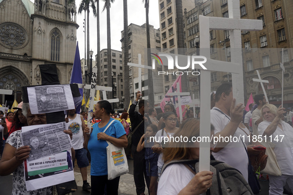 People hold crosses during a demonstration in downtown Sao Paulo, Brazil, on December 9, 2024, to protest against police violence following...