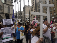 People hold crosses during a demonstration in downtown Sao Paulo, Brazil, on December 9, 2024, to protest against police violence following...