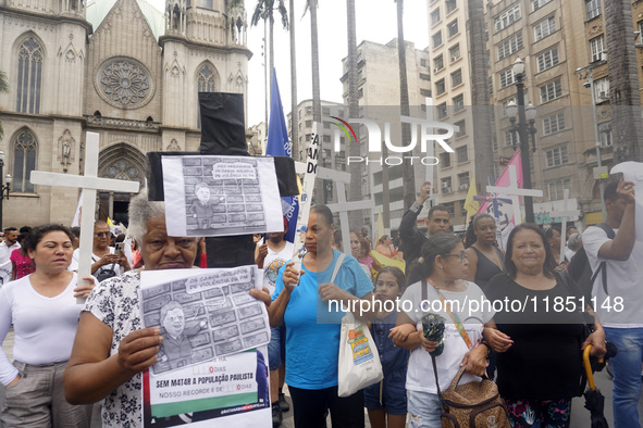 People hold crosses during a demonstration in downtown Sao Paulo, Brazil, on December 9, 2024, to protest against police violence following...