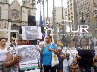 People hold crosses during a demonstration in downtown Sao Paulo, Brazil, on December 9, 2024, to protest against police violence following...