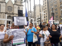 People hold crosses during a demonstration in downtown Sao Paulo, Brazil, on December 9, 2024, to protest against police violence following...