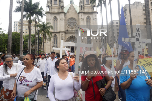 People hold crosses during a demonstration in downtown Sao Paulo, Brazil, on December 9, 2024, to protest against police violence following...