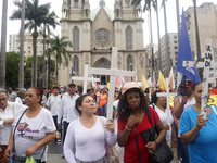 People hold crosses during a demonstration in downtown Sao Paulo, Brazil, on December 9, 2024, to protest against police violence following...