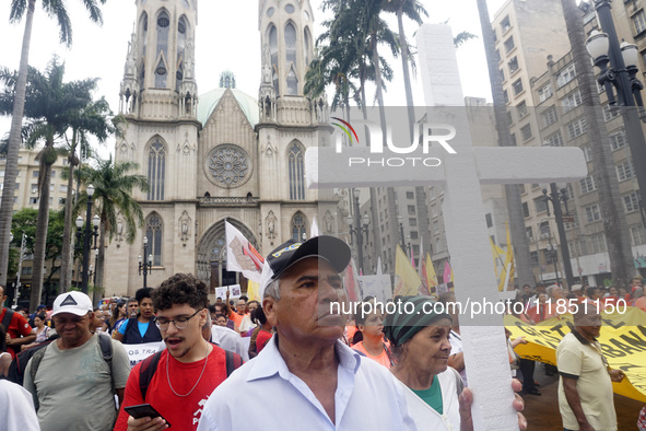 People hold crosses during a demonstration in downtown Sao Paulo, Brazil, on December 9, 2024, to protest against police violence following...