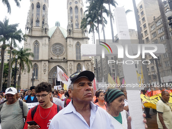 People hold crosses during a demonstration in downtown Sao Paulo, Brazil, on December 9, 2024, to protest against police violence following...