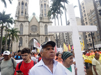 People hold crosses during a demonstration in downtown Sao Paulo, Brazil, on December 9, 2024, to protest against police violence following...