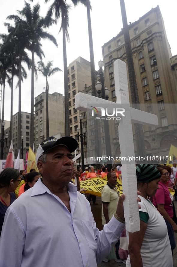 People hold crosses during a demonstration in downtown Sao Paulo, Brazil, on December 9, 2024, to protest against police violence following...