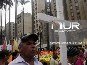 People hold crosses during a demonstration in downtown Sao Paulo, Brazil, on December 9, 2024, to protest against police violence following...