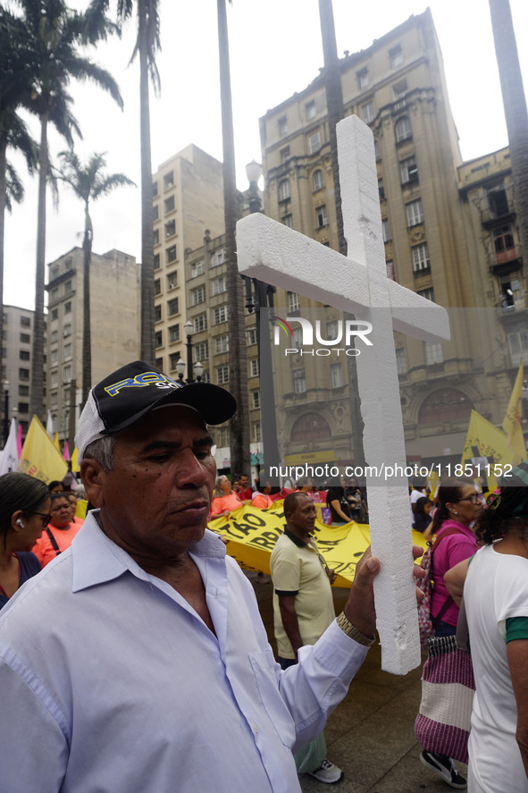 People hold crosses during a demonstration in downtown Sao Paulo, Brazil, on December 9, 2024, to protest against police violence following...