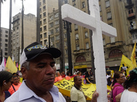 People hold crosses during a demonstration in downtown Sao Paulo, Brazil, on December 9, 2024, to protest against police violence following...