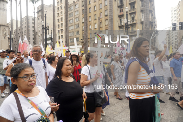 People hold crosses during a demonstration in downtown Sao Paulo, Brazil, on December 9, 2024, to protest against police violence following...