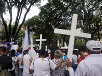 People hold crosses during a demonstration in downtown Sao Paulo, Brazil, on December 9, 2024, to protest against police violence following...