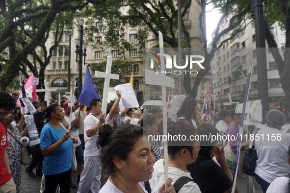 People hold crosses during a demonstration in downtown Sao Paulo, Brazil, on December 9, 2024, to protest against police violence following...