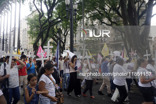 People hold crosses during a demonstration in downtown Sao Paulo, Brazil, on December 9, 2024, to protest against police violence following...