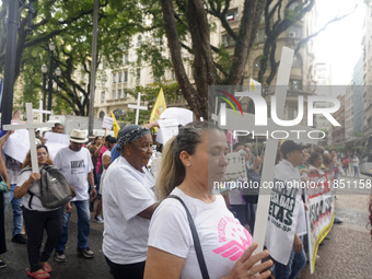 People hold crosses during a demonstration in downtown Sao Paulo, Brazil, on December 9, 2024, to protest against police violence following...