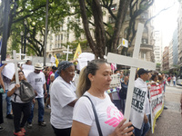 People hold crosses during a demonstration in downtown Sao Paulo, Brazil, on December 9, 2024, to protest against police violence following...