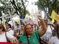 People hold crosses during a demonstration in downtown Sao Paulo, Brazil, on December 9, 2024, to protest against police violence following...