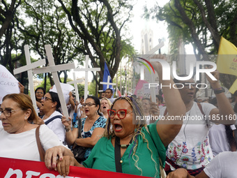 People hold crosses during a demonstration in downtown Sao Paulo, Brazil, on December 9, 2024, to protest against police violence following...