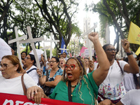 People hold crosses during a demonstration in downtown Sao Paulo, Brazil, on December 9, 2024, to protest against police violence following...