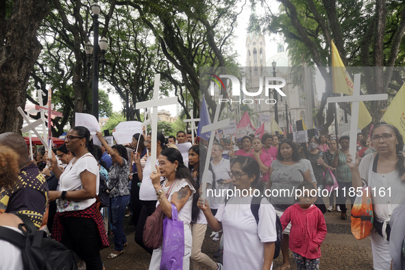 People hold crosses during a demonstration in downtown Sao Paulo, Brazil, on December 9, 2024, to protest against police violence following...