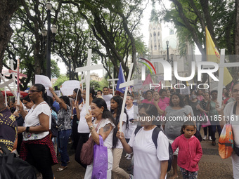 People hold crosses during a demonstration in downtown Sao Paulo, Brazil, on December 9, 2024, to protest against police violence following...