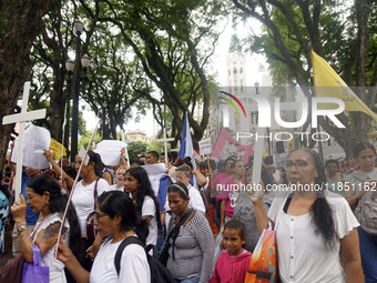 People hold crosses during a demonstration in downtown Sao Paulo, Brazil, on December 9, 2024, to protest against police violence following...