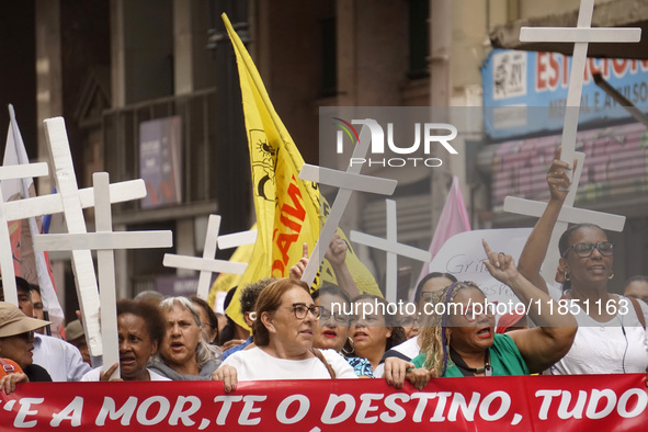 People hold crosses during a demonstration in downtown Sao Paulo, Brazil, on December 9, 2024, to protest against police violence following...