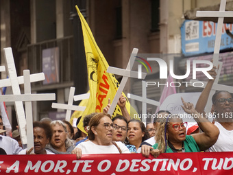 People hold crosses during a demonstration in downtown Sao Paulo, Brazil, on December 9, 2024, to protest against police violence following...