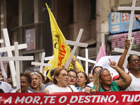 People hold crosses during a demonstration in downtown Sao Paulo, Brazil, on December 9, 2024, to protest against police violence following...