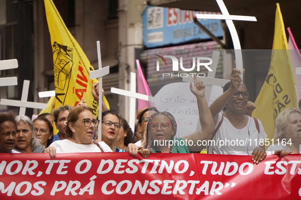 People hold crosses during a demonstration in downtown Sao Paulo, Brazil, on December 9, 2024, to protest against police violence following...