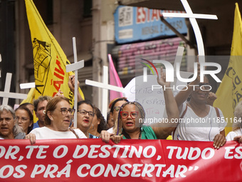 People hold crosses during a demonstration in downtown Sao Paulo, Brazil, on December 9, 2024, to protest against police violence following...