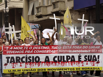 People hold crosses during a demonstration in downtown Sao Paulo, Brazil, on December 9, 2024, to protest against police violence following...