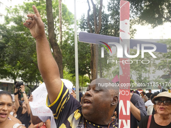 People hold crosses during a demonstration in downtown Sao Paulo, Brazil, on December 9, 2024, to protest against police violence following...