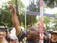 People hold crosses during a demonstration in downtown Sao Paulo, Brazil, on December 9, 2024, to protest against police violence following...