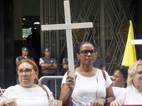 People hold crosses during a demonstration in downtown Sao Paulo, Brazil, on December 9, 2024, to protest against police violence following...