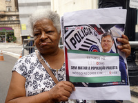 People hold crosses during a demonstration in downtown Sao Paulo, Brazil, on December 9, 2024, to protest against police violence following...