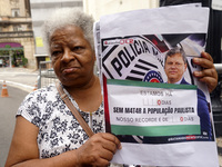 People hold crosses during a demonstration in downtown Sao Paulo, Brazil, on December 9, 2024, to protest against police violence following...