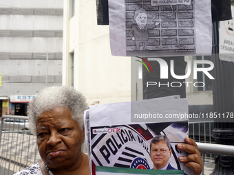 People hold crosses during a demonstration in downtown Sao Paulo, Brazil, on December 9, 2024, to protest against police violence following...