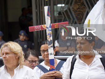 People hold crosses during a demonstration in downtown Sao Paulo, Brazil, on December 9, 2024, to protest against police violence following...