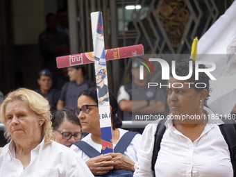 People hold crosses during a demonstration in downtown Sao Paulo, Brazil, on December 9, 2024, to protest against police violence following...