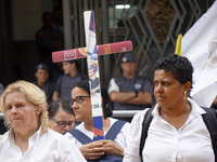 People hold crosses during a demonstration in downtown Sao Paulo, Brazil, on December 9, 2024, to protest against police violence following...